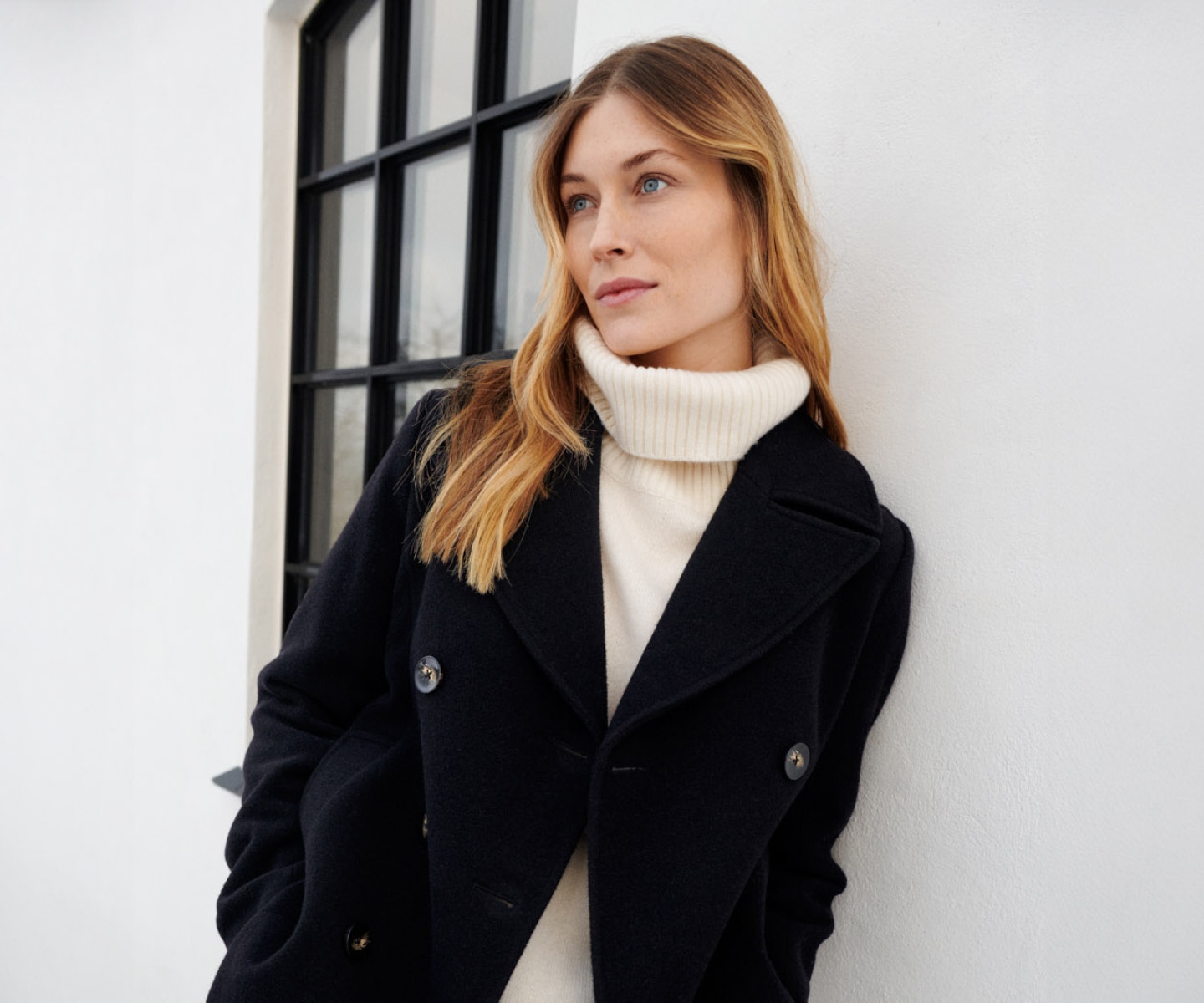 Woman in white knit and black wool coat